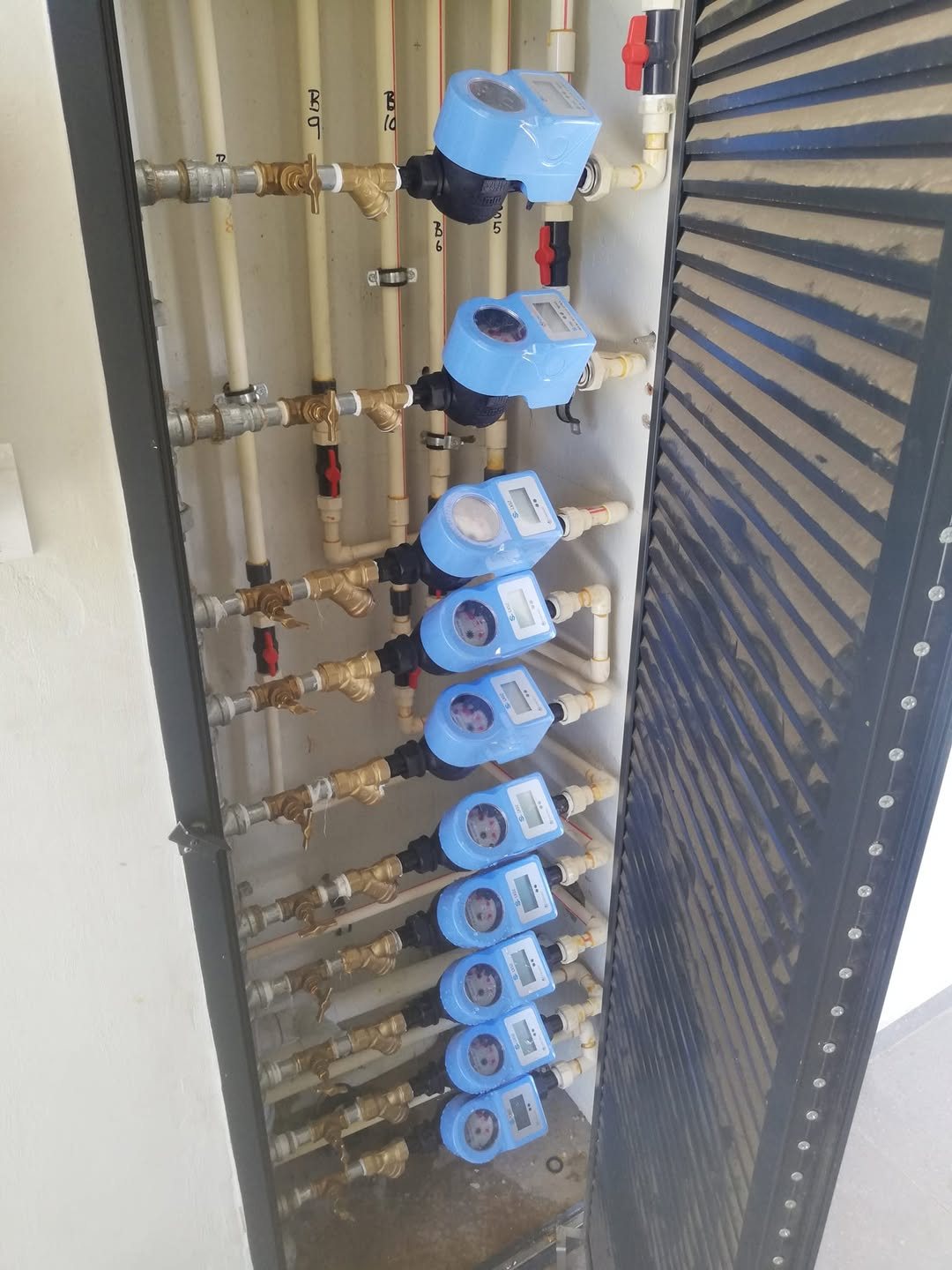 A bank of prepaid water meters in a riser cupboard